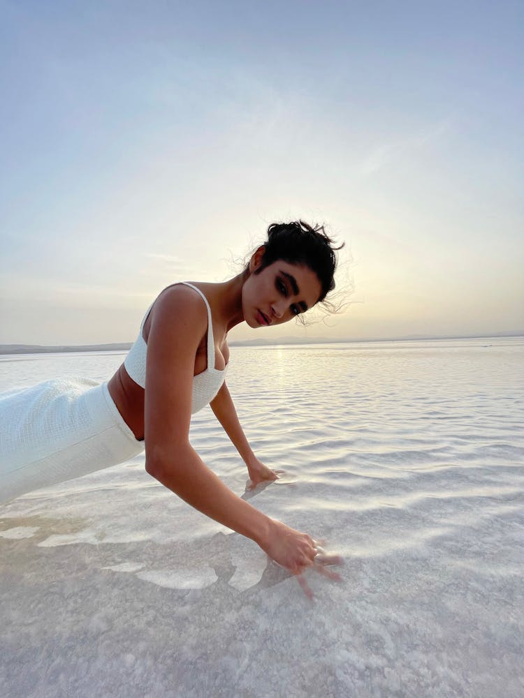 Ethnic Woman Pushing Up In Shallow Seawater