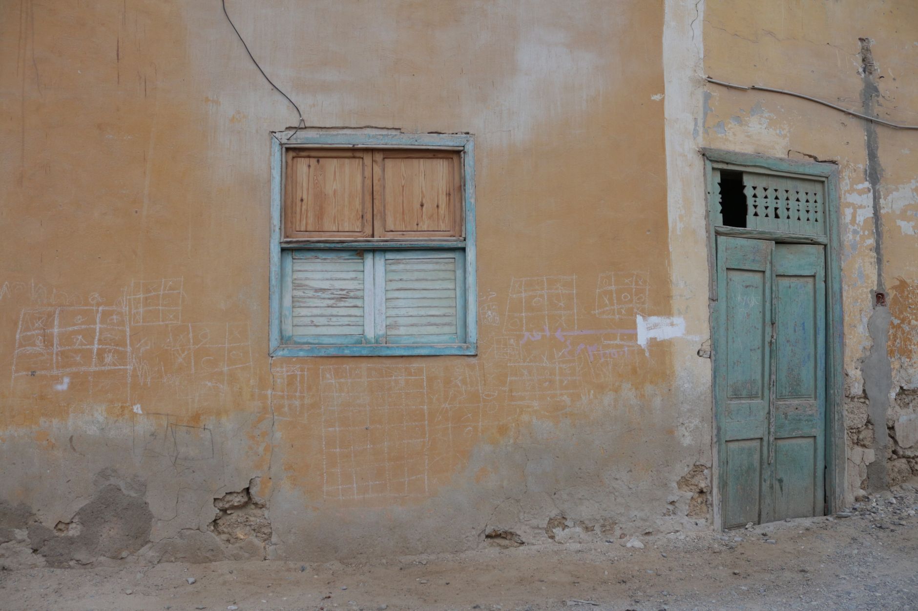 家裡灰塵一直回來?你可能忽略的6個原因 A neglected building facade featuring a window and door with visible wear and decay.
