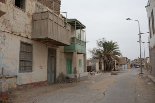 Desolate street with aged buildings and wooden balconies, evoking a rustic charm.