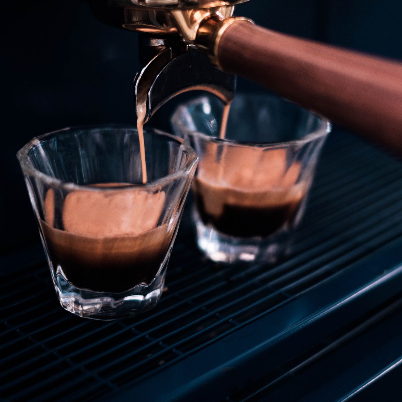Fragrant delicious coffee poured into clean transparent glasses in kitchen of contemporary cafe