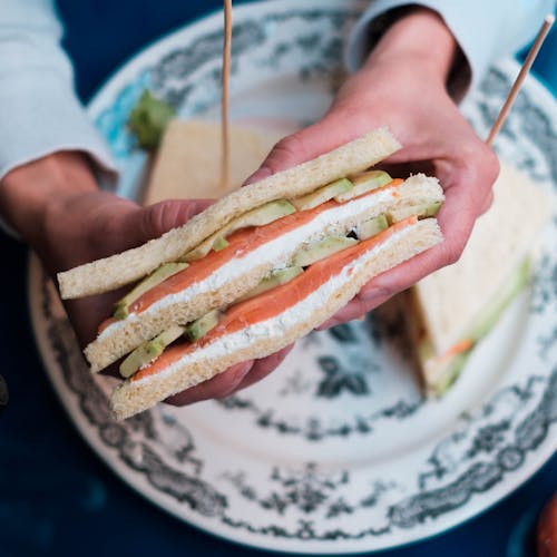 Person showing tasty fish sandwich in restaurant