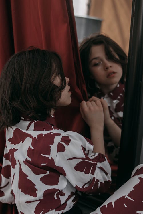 A Woman Wearing a Tropical Dress in front of a Mirror