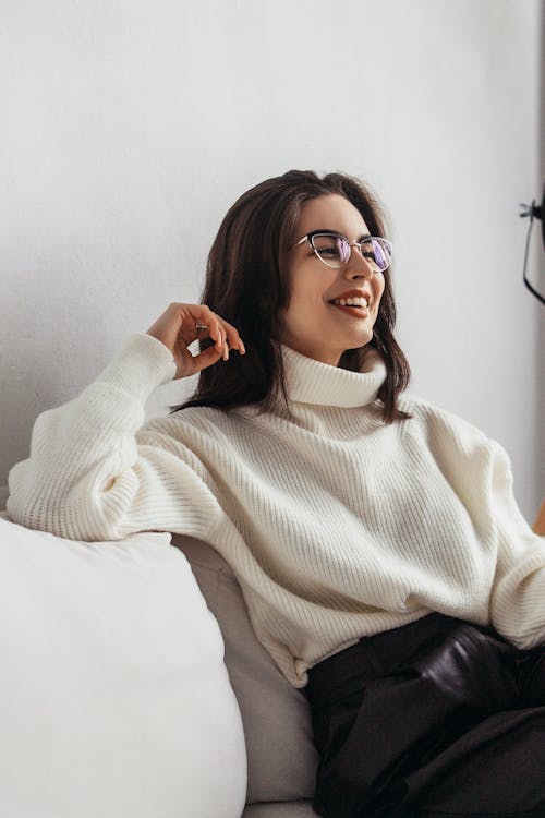 Smiling stylish woman sitting on couch