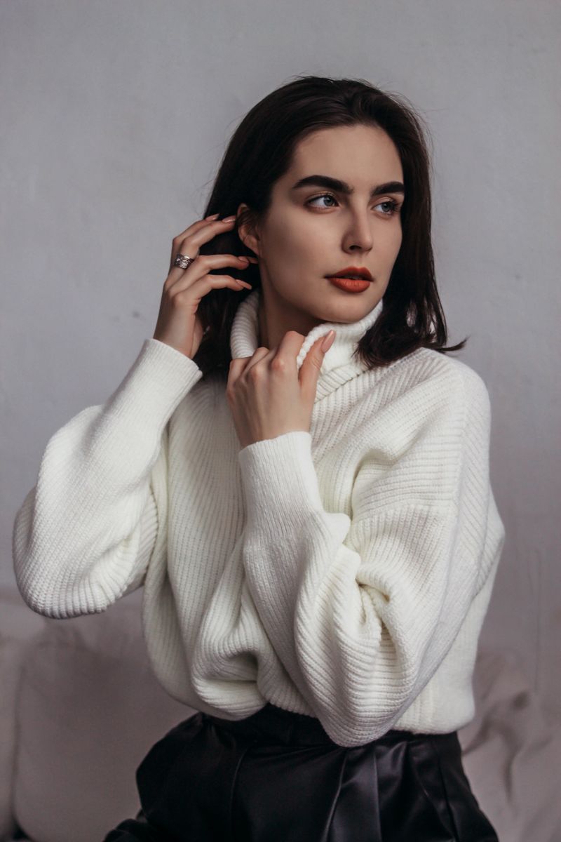 woman in black leather midi skirt and cream knit sweater