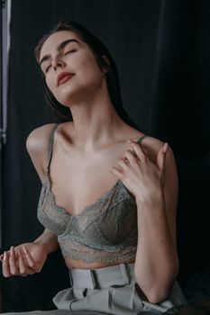 Elegant woman in lace lingerie exuding confidence in a stylish indoor setting.