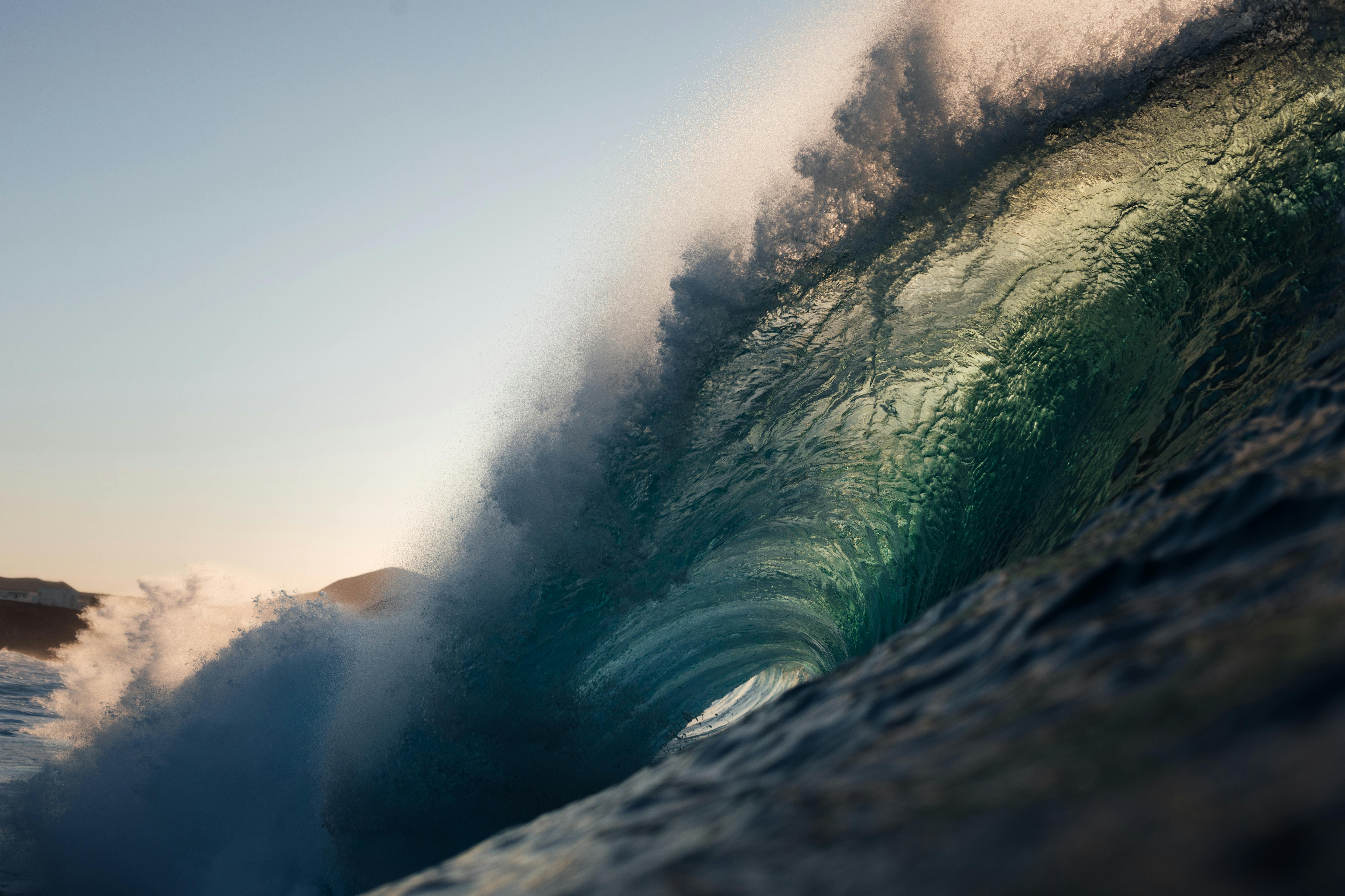 Captivating view of a powerful ocean wave crashing at sunset in Lanzarote, Spain.