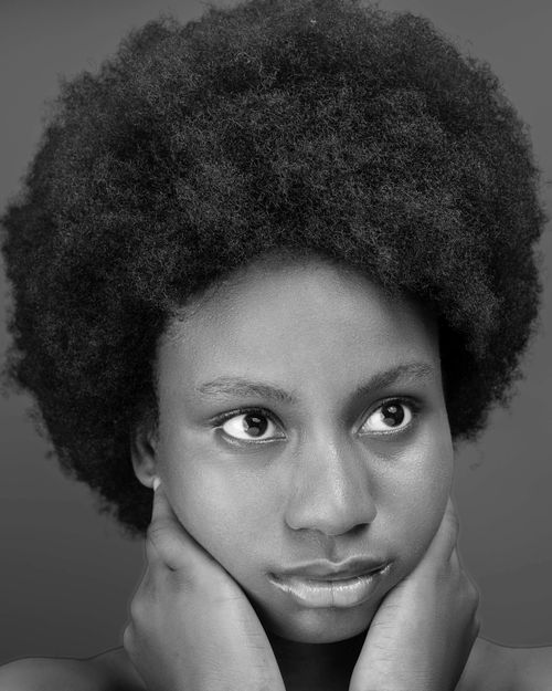 Free Striking black and white portrait of a woman with an afro hairstyle, exuding elegance and confidence. Stock Photo