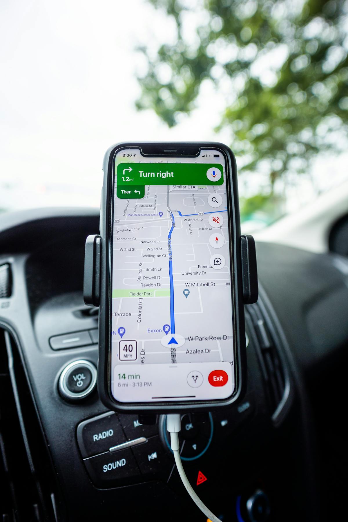 Smartphone with GPS navigation app mounted on car dashboard for EV road trip route planning