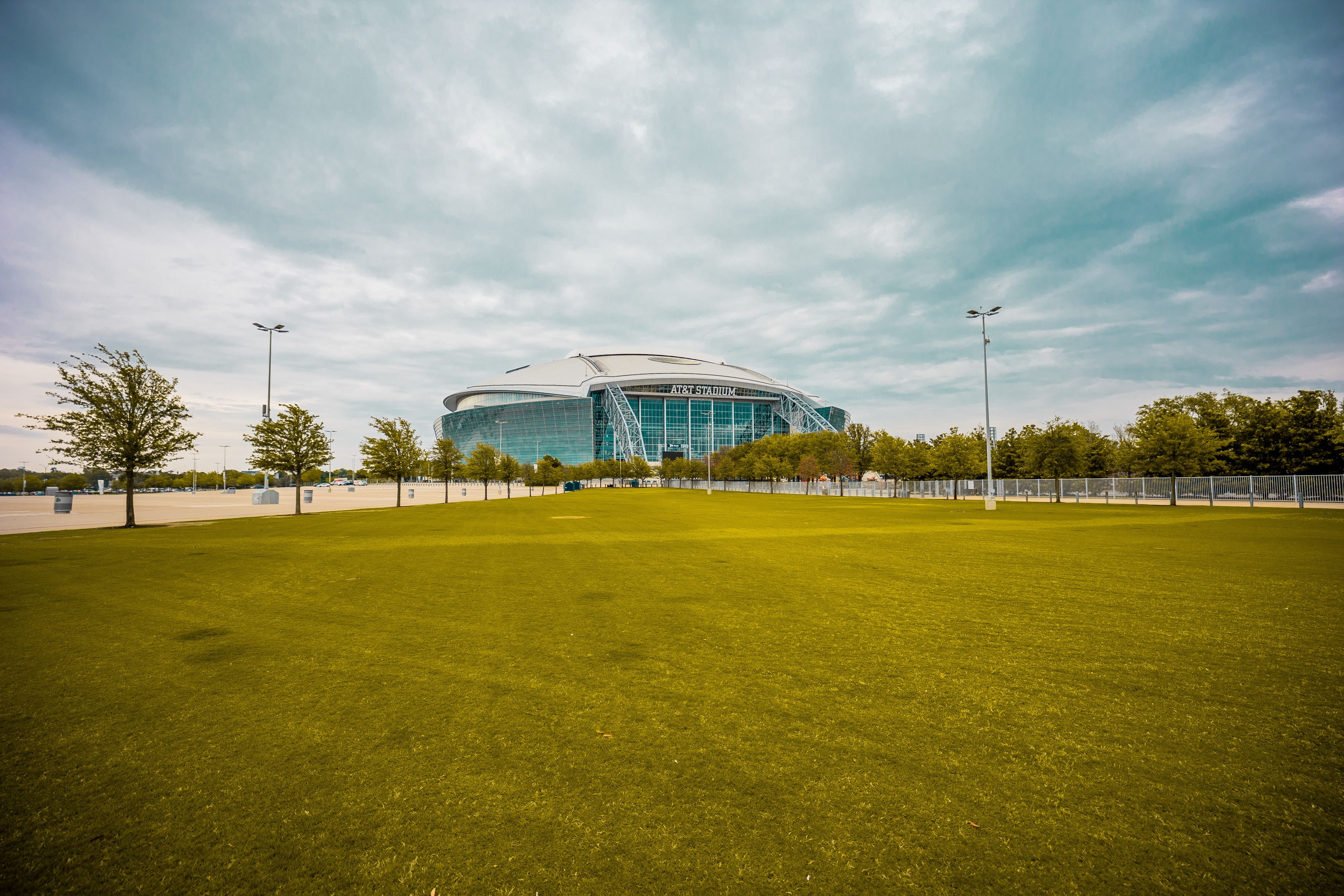 Arlington: AT&T Stadium beyond a green lawn in Arlington