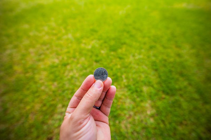 Hand holding a discovered coin from metal detecting