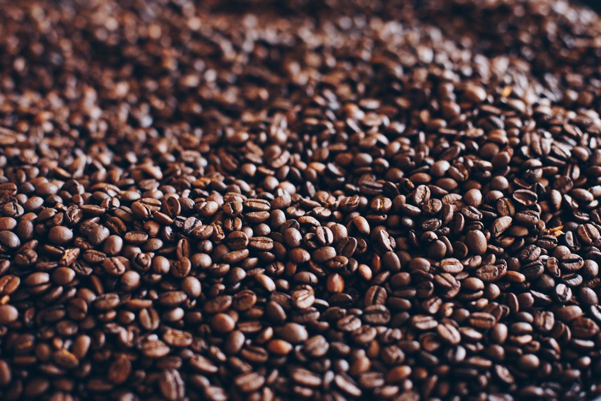 Close-up of fresh roasted coffee beans — coffee is measured by weight, not volume, because bean density varies significantly between roast levels and origins