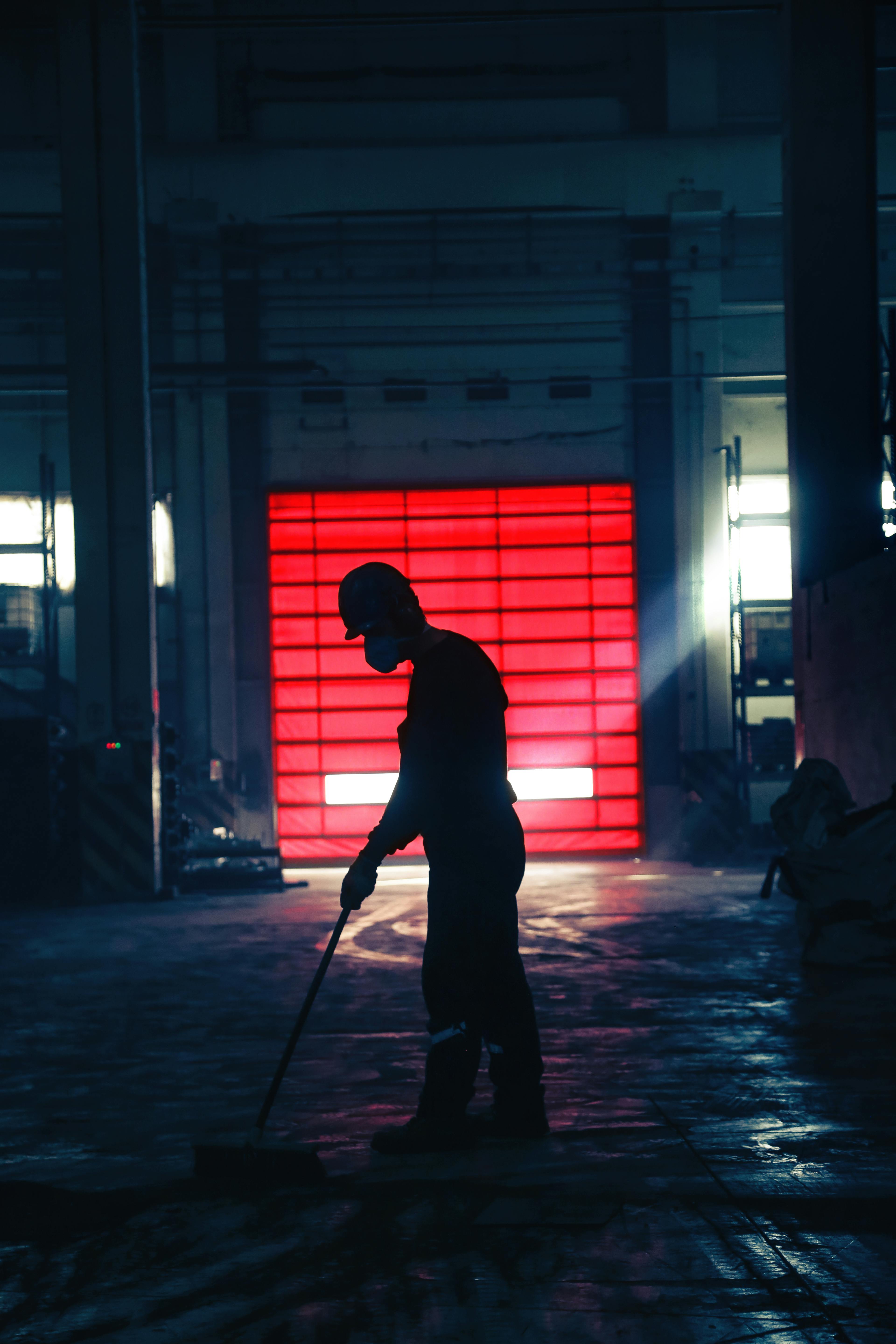 An image of a janitor cleaning the floor in a factory