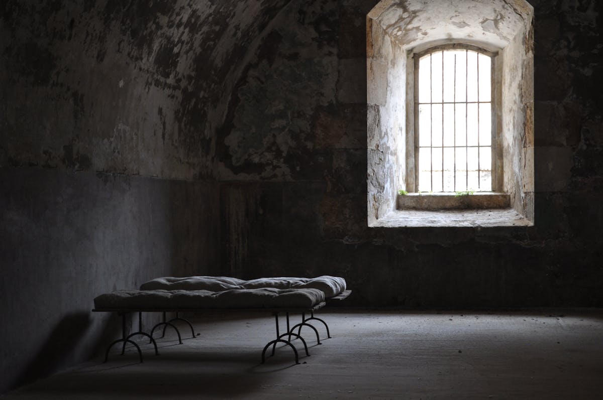 White Mattresses on Black Metal Bed Frame Near Window