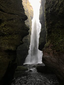 Discover the pristine beauty of a hidden Icelandic waterfall surrounded by moss-covered rocks.