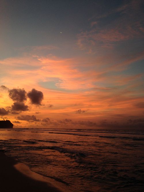 Free A breathtaking sunset over Bali's coastline, capturing vivid colors and serene waves. Stock Photo