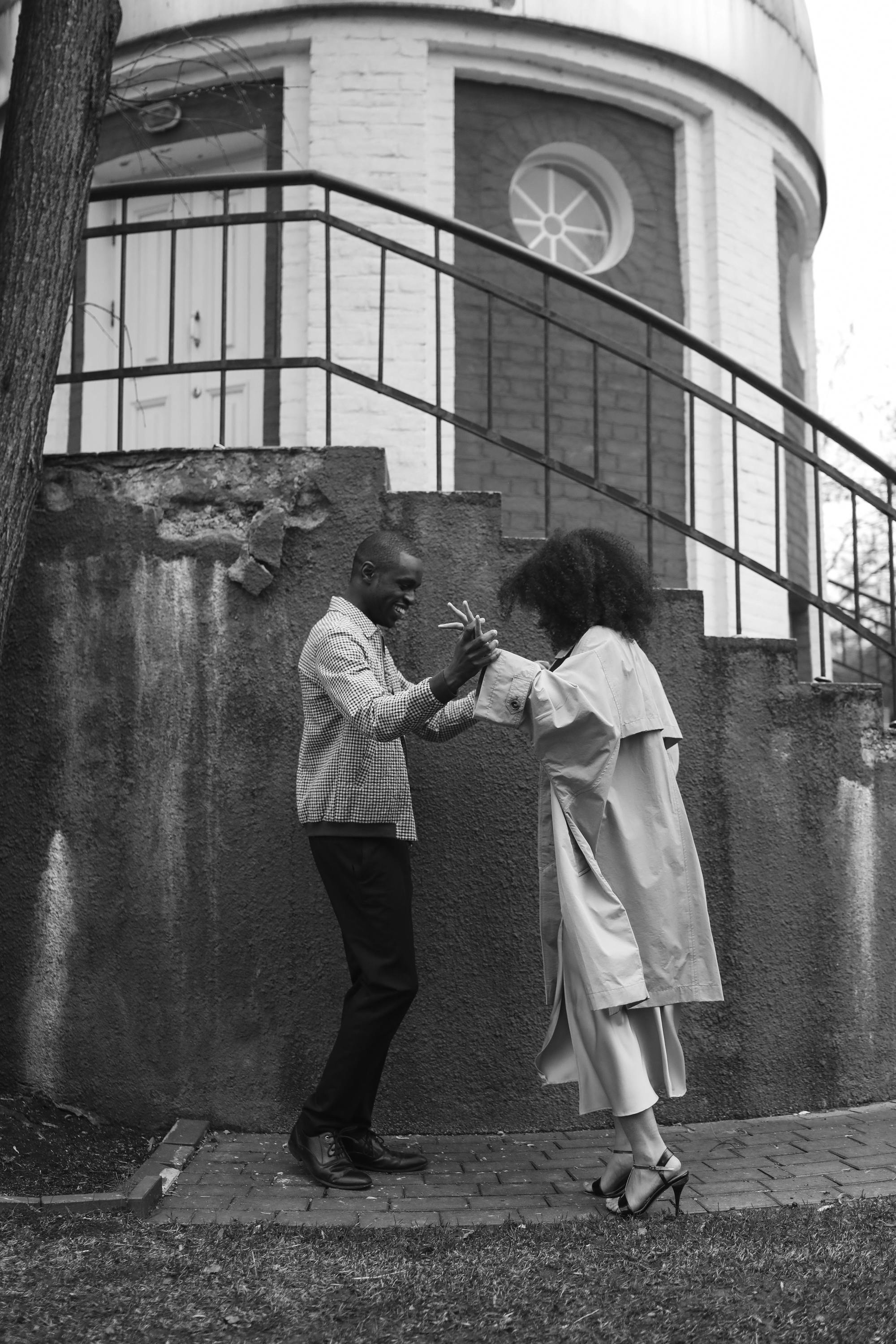 African American couple dancing joyfully in an outdoor setting.