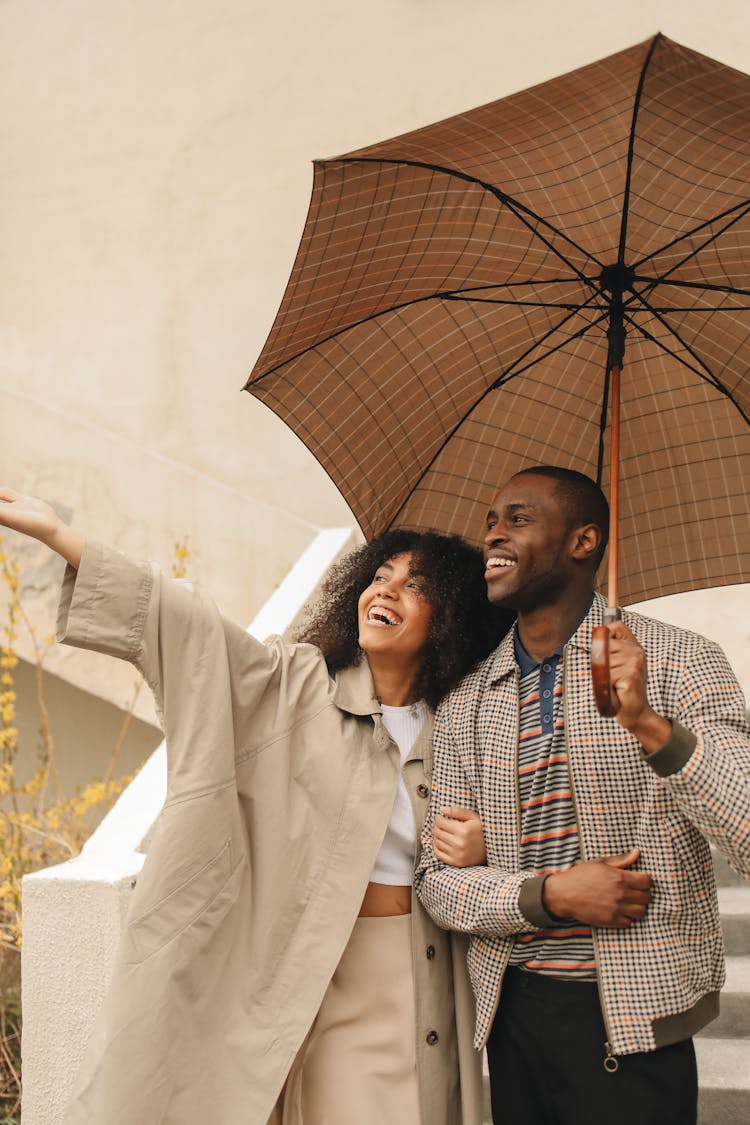 Woman Beside Man In Plaid Jacket Holding Umbrella 