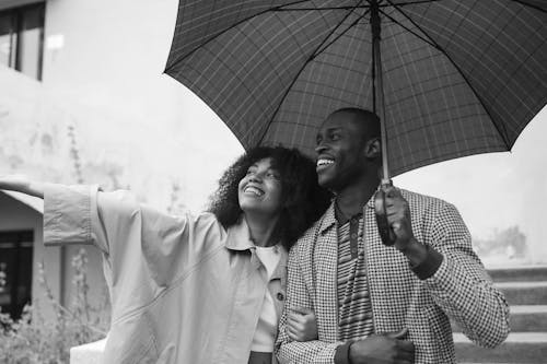 Black and White Photography of Couple Under Umbrella