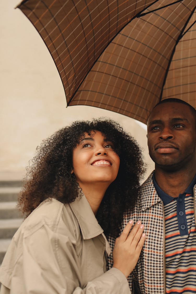 Man And Woman Under Brown Umbrella