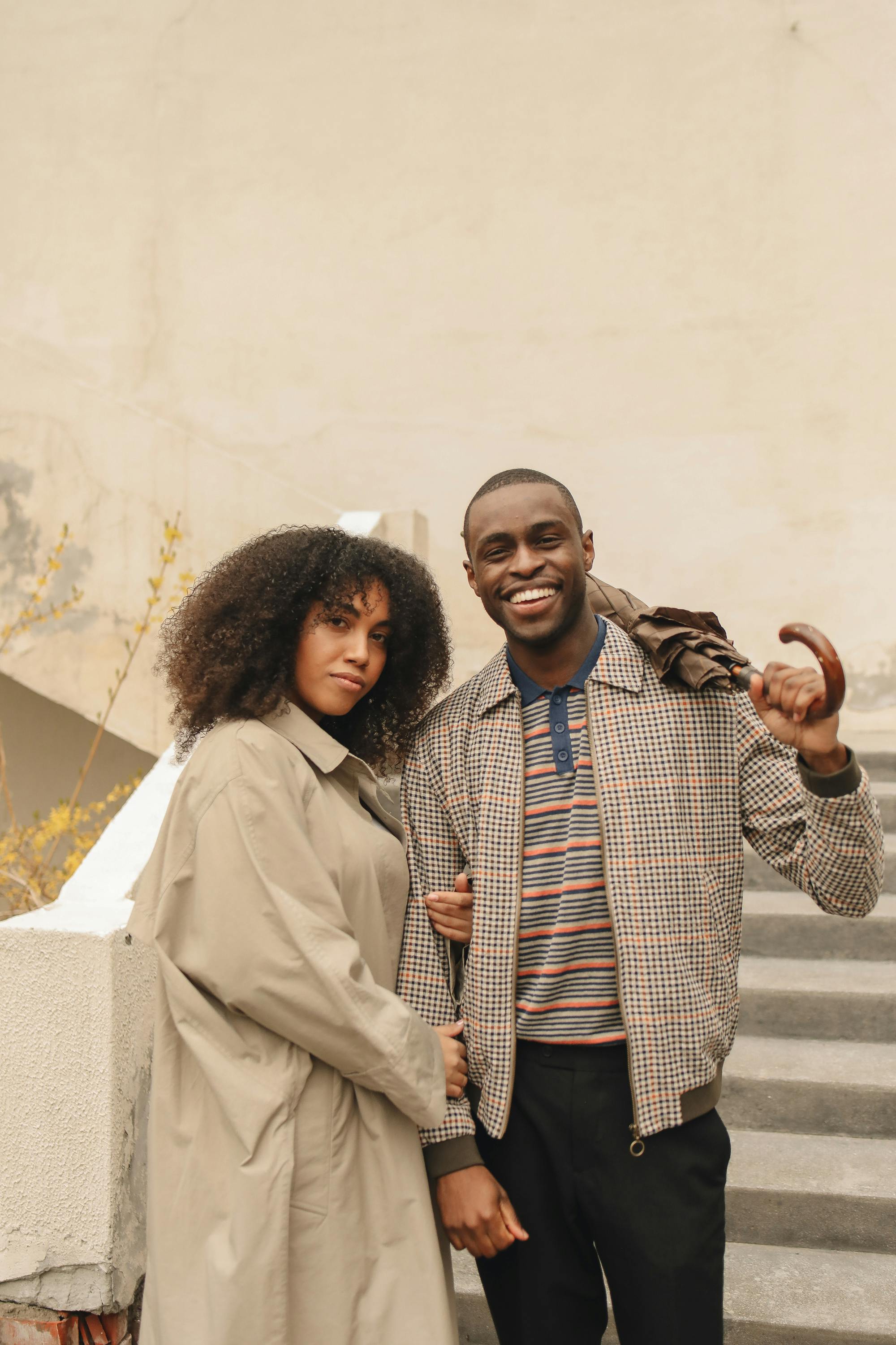 woman in brown coat holding man in plaid jacket