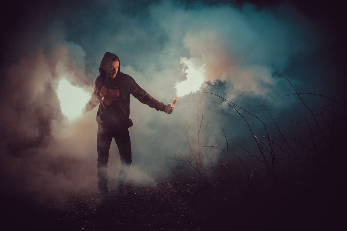 Man in Black Hoodie Holding Fire