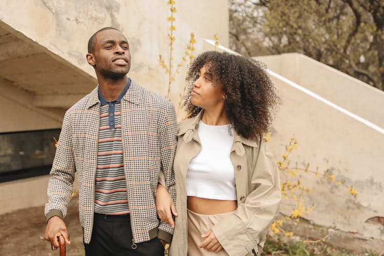 Woman In Brown Coat Looking At Man In Plaid Jacket