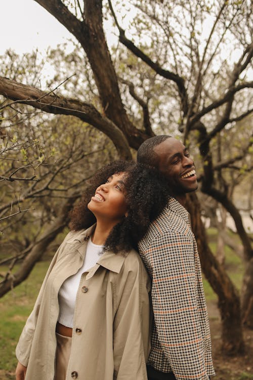 Photo of a Couple Smiling while Back to Back