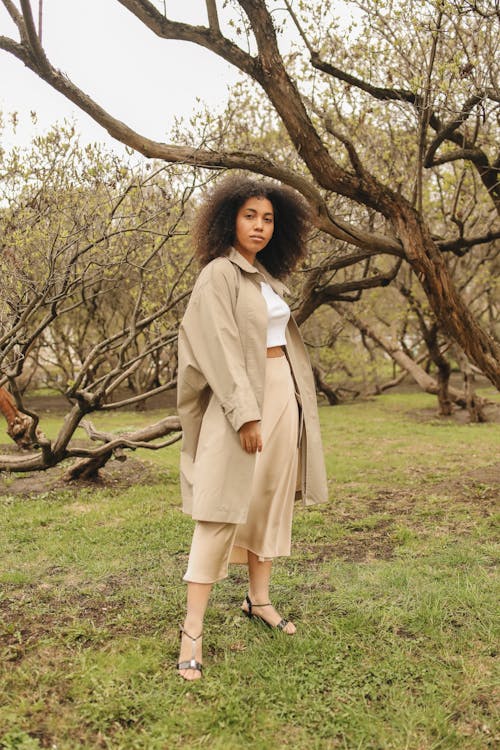 Woman in Beige Clothes Posing Near a Tree
