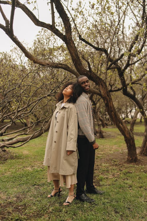 A Man and a Woman Back to Back Near Trees