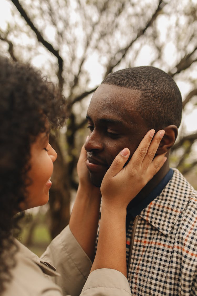 Close-up Of A Woman Holding The Face Of A Man