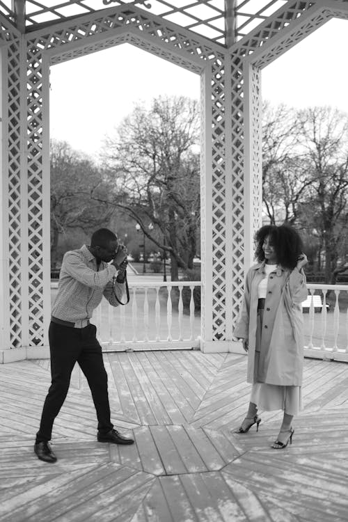 Grayscale Photo of a Man Taking a Photo of a Woman