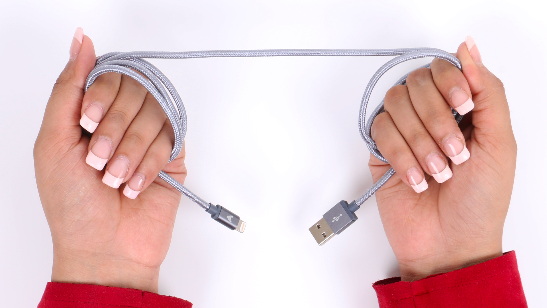 Close-up of hands holding a USB cable on a white surface, highlighting connection and technology.