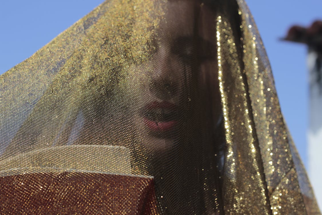 Woman Under Gold Glittering Veil