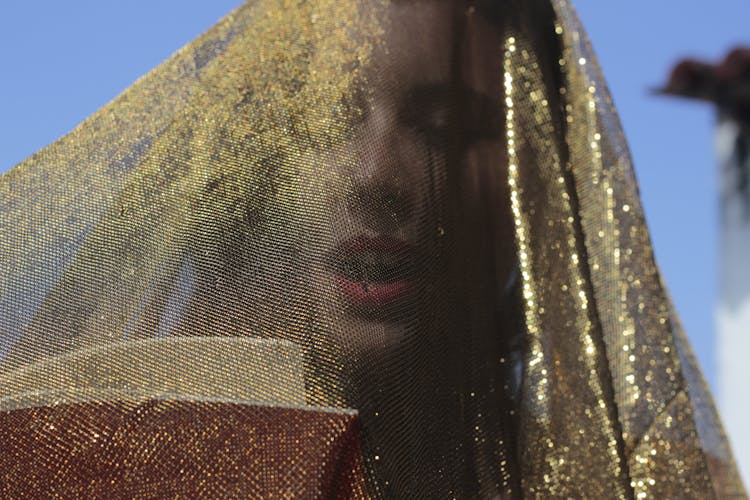 Woman Under Gold Glittering Veil