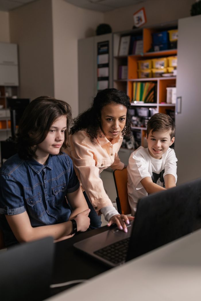 Diverse students collaborating with a teacher in a tech-enabled classroom