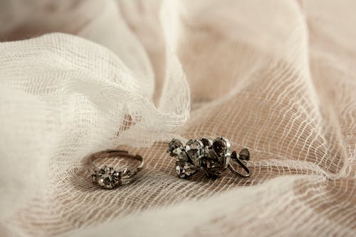 Close-Up Shot of a Ring and Earrings on a White Textile