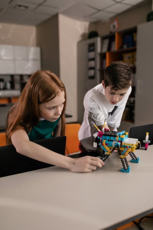 Free Boy and Girl Playing with Robot Stock Photo