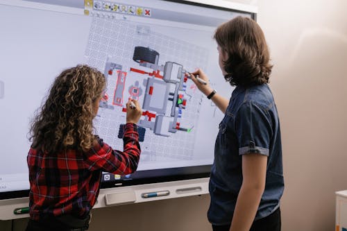 Two Students Using an Interactive Board