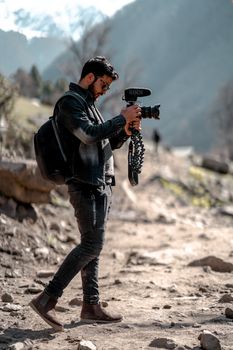 Photographer capturing stunning mountain scenery during daylight with camera gear.