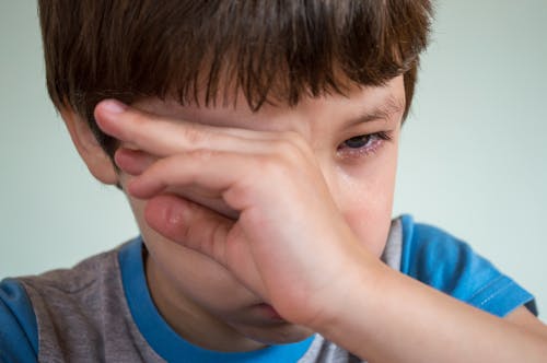 Boy Wiping Tears from Eye
