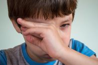 Boy Wiping Tears from Eye