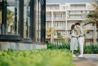 Gentle Asian couple holding hands among modern buildings