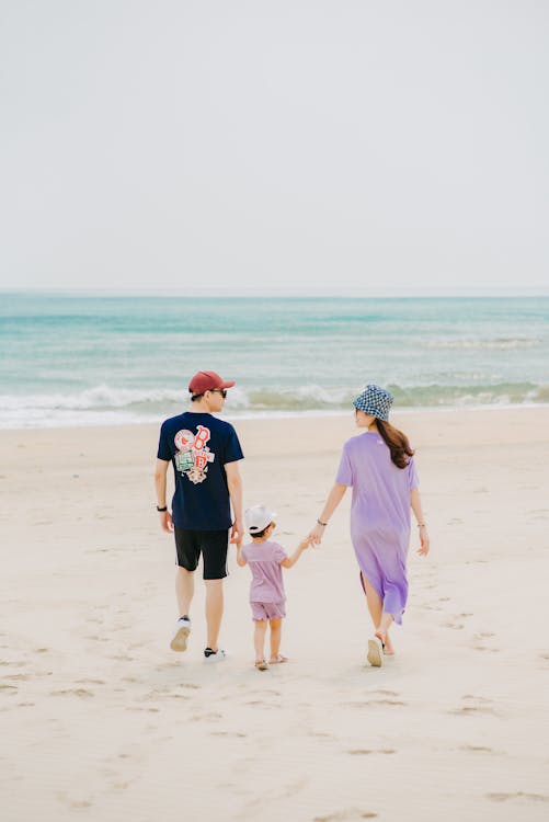 Free Loving mother and father holding hands with little cute offspring Stock Photo