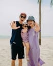 Cheerful Asian family showing palms on beach