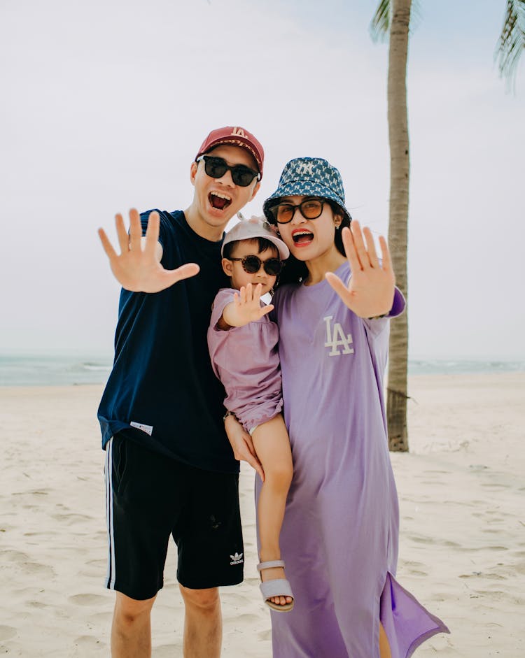 Cheerful Asian Family Showing Palms On Beach