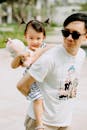 Happy Asian father and cute daughter with toy in arms