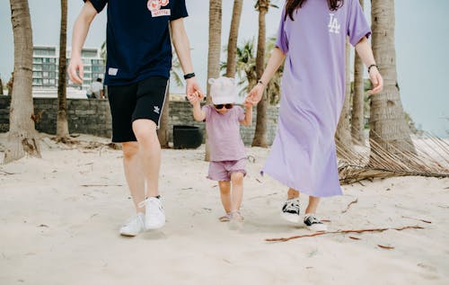 Free Crop of young family walking on beach Stock Photo