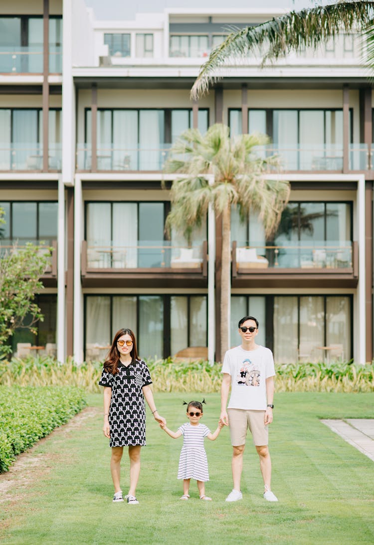 Young Asian Family In Front Of Hotel