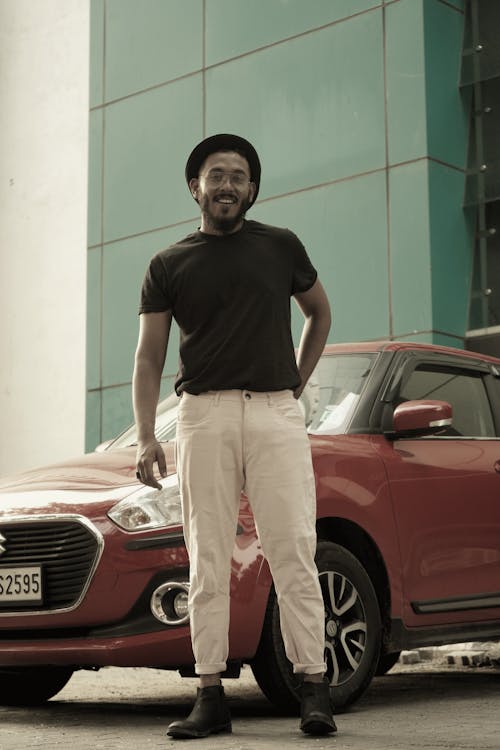 Man in Black Crew Neck T-shirt Standing Beside Red Car