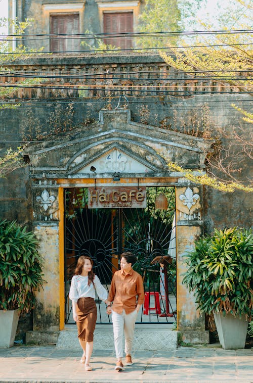 A Couple Holding Hands while Walking